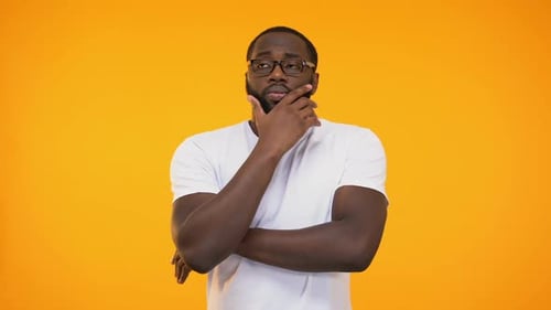 Bearded Man Thinking Intently Against Yellow Background