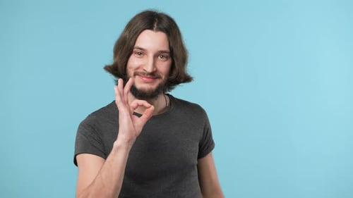 Man with Long Hair Makes Okay Gesture