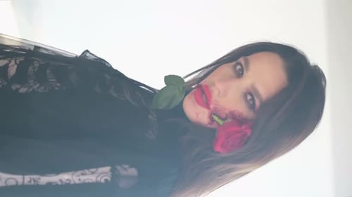 Stylish Young Adult With Rose in Mouth Posing