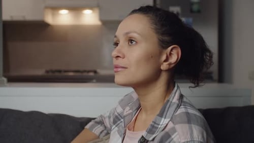 Woman Relaxes on Couch in Bright Home Interior