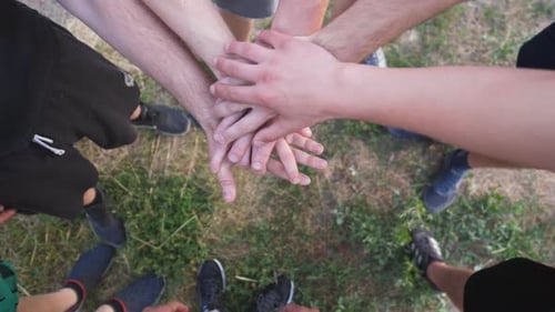 Top View Hands of Young Athletes Stacking Together One By One in Unity