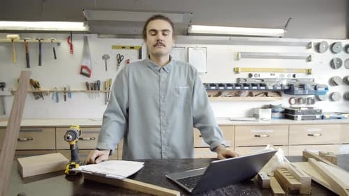 Carpentry Workshop Owner Posing with Laptop, Wooden Parts and Tools