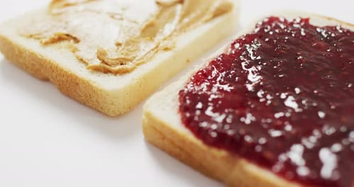Close up view of peanut butter and jelly sandwich with copy space on white surface