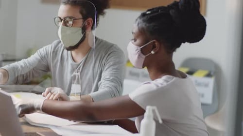 Diverse Employees in Masks and Gloves Coworking in Office during Pandemic