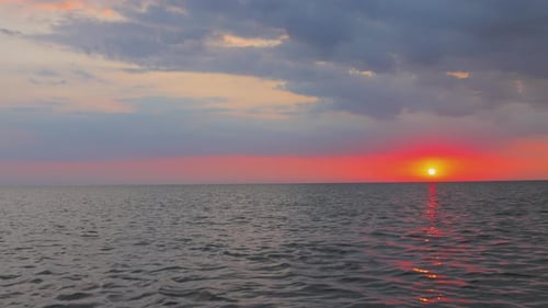 Puesta de sol anaranjada por la noche en el horizonte sobre el lago