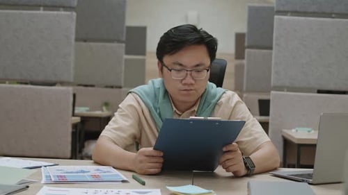 Office Workers Reviewing Business Plan at Meeting