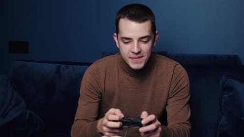 Enthusiastic Man Playing Video Game on Couch
