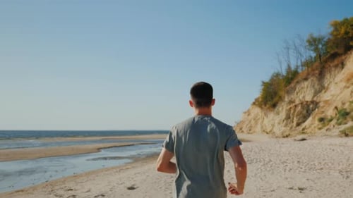 Young Man Jogging on the Beach in a Picturesque Place