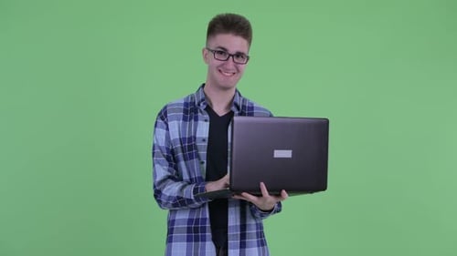 Young Adult Using Laptop in Front of Green Screen