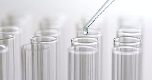 Liquid Dropping into Glass Test Tube in Lab