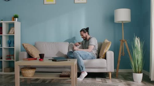 Man Video Calling on Tablet in Light Blue Living Room