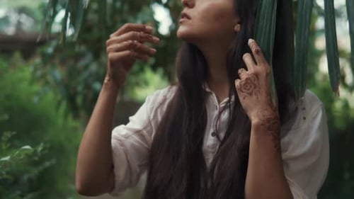 Woman with Henna Amongst Lush Green Foliage