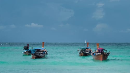 Four Long-tailed Boat Swinging in Blue Waves, White Sail Boat on the Horizon, Koh Lipe Thailand