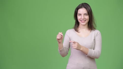 Junge glücklich schöne Frau zeigt etwas, während sie mit dem Finger nach oben zeigt