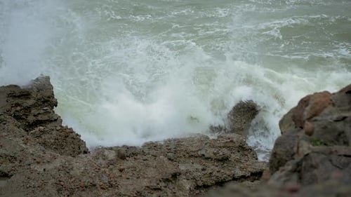 Big stormy waves breaking against abandoned seaside fortification building ruins at Karosta Northern