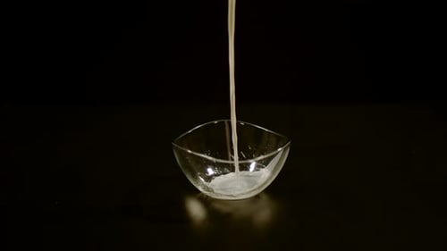 Pouring Milk and Cereal into Clear Bowl