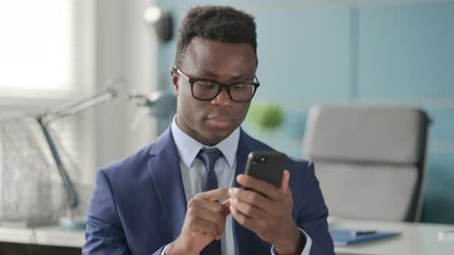 Man in Suit Using Smartphone in Office