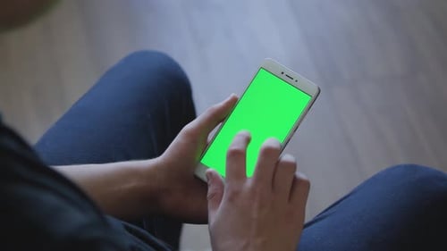 Closeup of Male Hands Holding Smart Phone with Green Screen Prekeyed for Effects. Useful Mobile