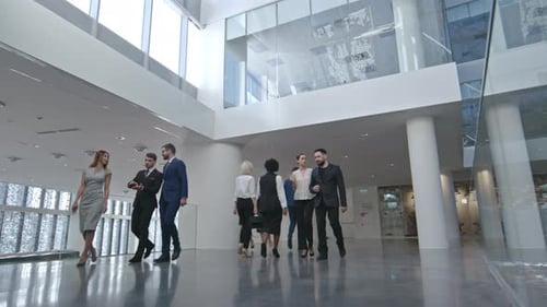 Group of Young Adults Walking Through Office Lobby