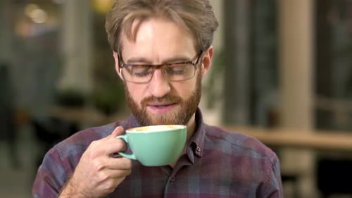 Man Drinks Coffee in Office Smiling Portrait