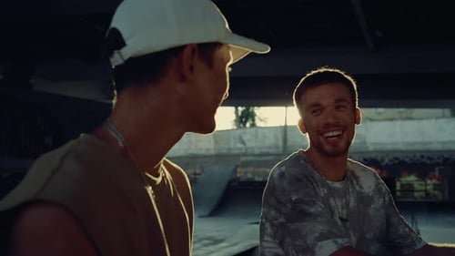 Young Men Talking in a Skatepark at Sunset