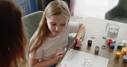 Girl Painting with Watercolors with Adult Assistance