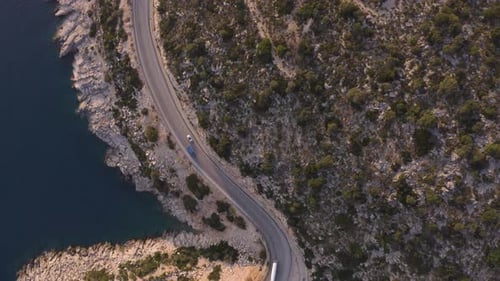 Aerial View of Road Near Blue Sea and Green Mountain in Summer