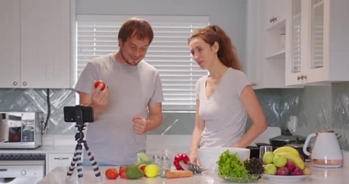 Young Couple in Kitchen Shooting Video Food Blog About Cooking at Home