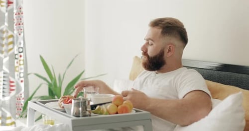 Man in Bed Takes Pills With Water
