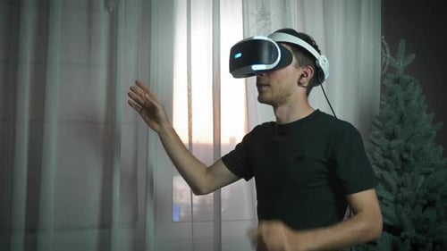Junger freudiger aufgeregter Mann trägt Virtual-Reality-Headset