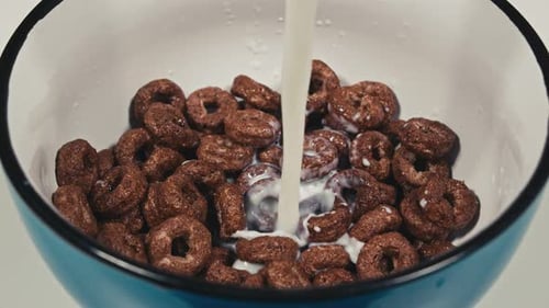 Pouring Milk into Chocolate Ring Cereal Bowl