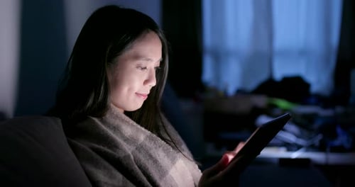 Asian woman use of tablet computer at home in the evening