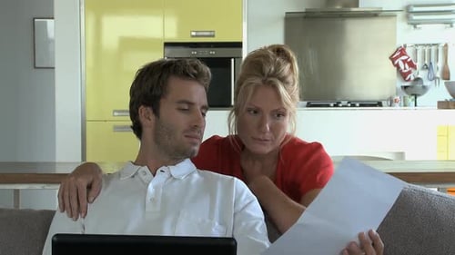 Happy Couple Relaxing Indoors with Laptop and Document