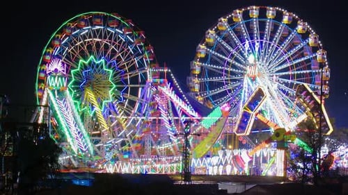 Brightly Lit Carnival at Night with Ferris Wheels