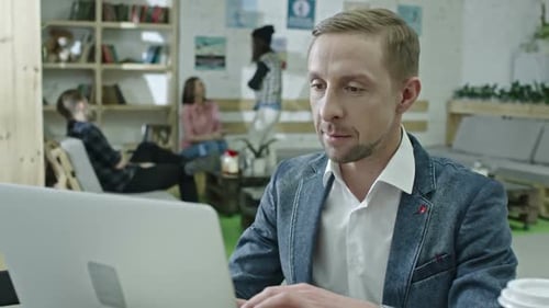 Adult Typing on Laptop at Wooden Desk