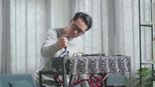 Asian Man Wearing Glasses Cleans The Mining Rig For Mining Cryptocurrency