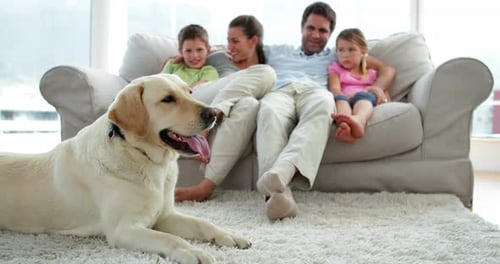 Family Relaxing on Couch With Dog