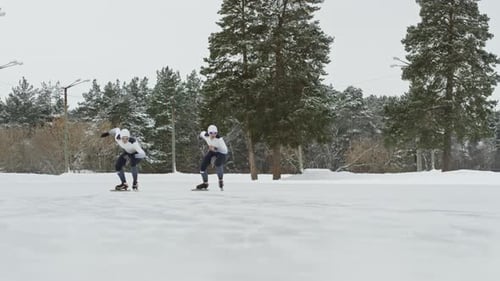 Athletes Speed Skating on Snowy Winter Landscape