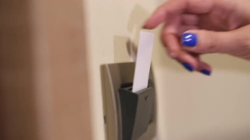 Person Hand Takes Hotel Card From Room Card Holder Closeup