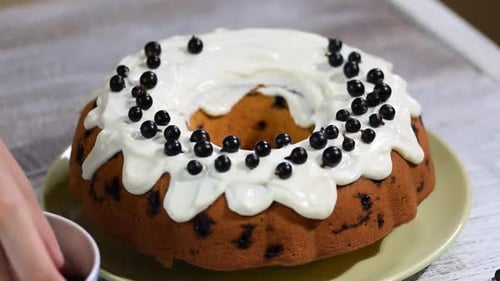 Decorating sponge cake with black currant