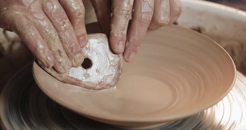 Potter in the Potter's Wheel Makes Ceramic Product Using His Hands and Pottery Tools. Close Up