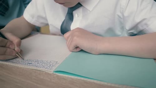 Child Writing Numbers in School Notebook