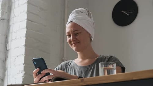 Woman Using Phone After Shower at Home