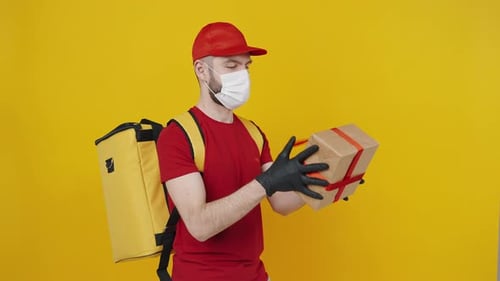 Delivery Man Holds Gift Box Wearing Mask