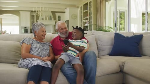 Grandparents Laughing with Grandchild on Couch