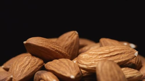 Macro shot of falling of almond on a heap