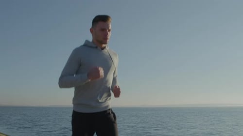 Man Jogging Near the Ocean on a Sunny Day