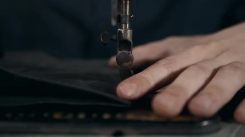 Hands Sewing Black Fabric with Sewing Machine