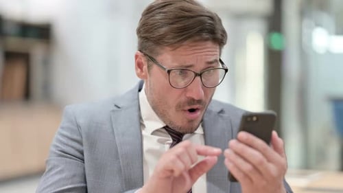 Shocked Man Reacting to News on Phone