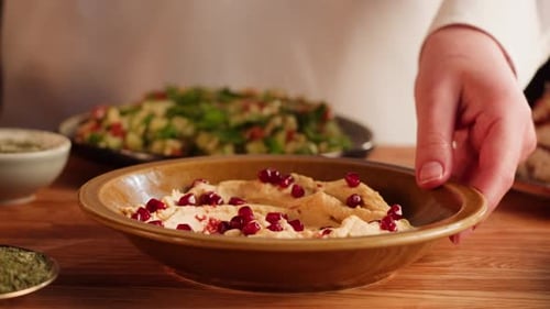 Person dips Pita Bread into Hummus